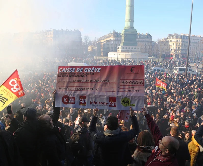 Chèque géant de 40 000 € remis par la Caisse de solidarité aux salariés grévistes de l’Opéra de Paris, brandi lors d’un rassemblement place de la Bastille.